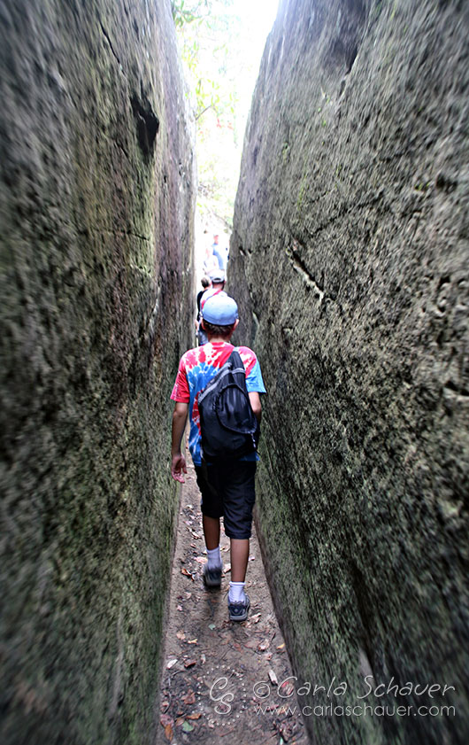 Teenager walking through rock tunnel