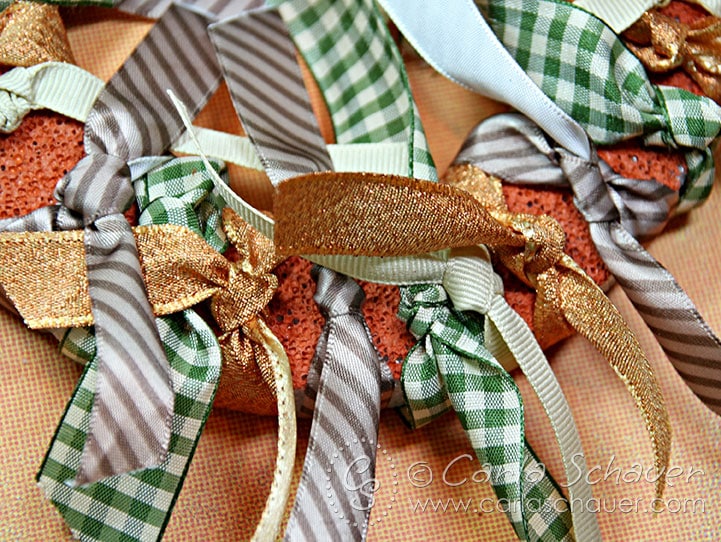 Close-up of knotted brown, green, and gold ribbons.