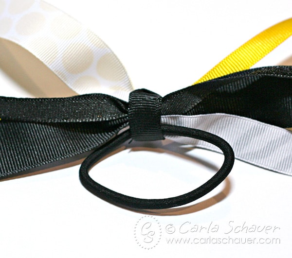 yellow, black, and white ribbon streamers on black ponytail band