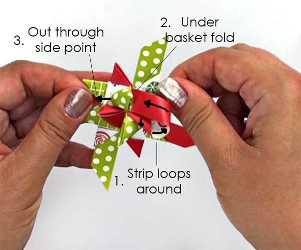 Hands folding paper strips to make German star ornaments.