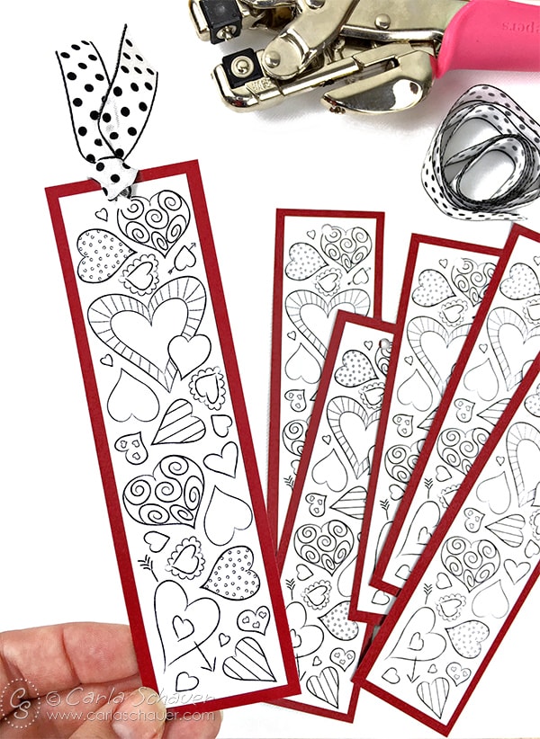 Black and white heart bookmarks with red borders, with craft supplies on white background.