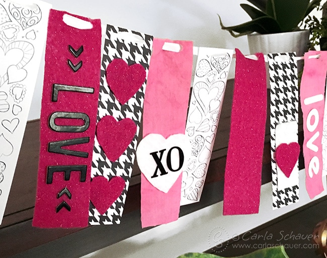 Make a Valentine Garland Decoration using free printable coloring bookmarks, and strips of fabric and paper. Adorable!