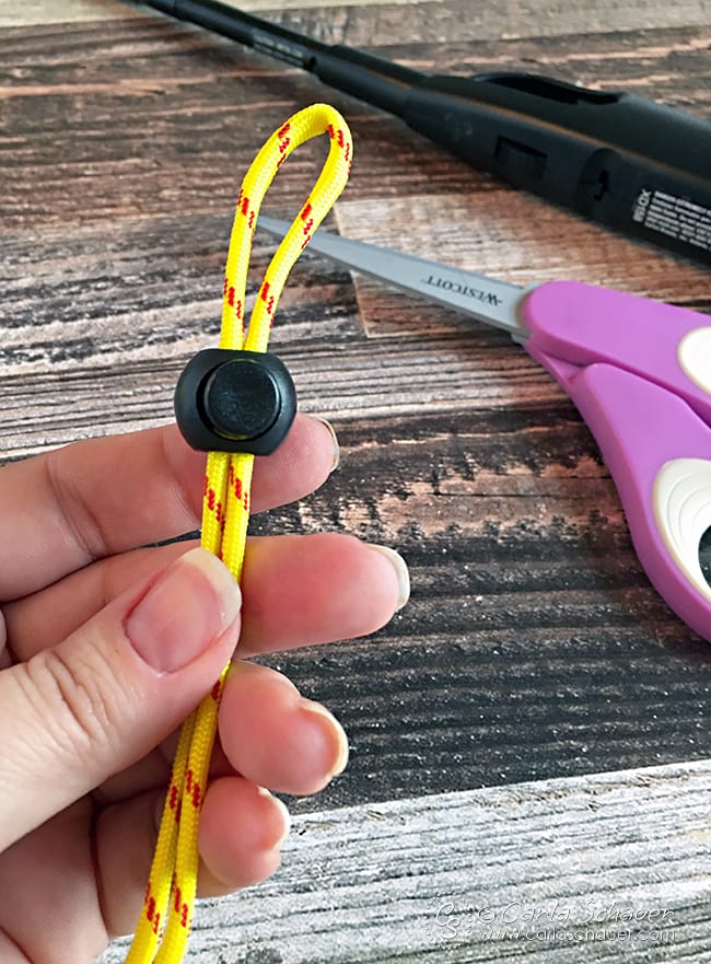 Adjustable water bottle loop allows for a variety of sizes when making a paracord water bottle holder. | Tutorial from Carla Schauer Designs