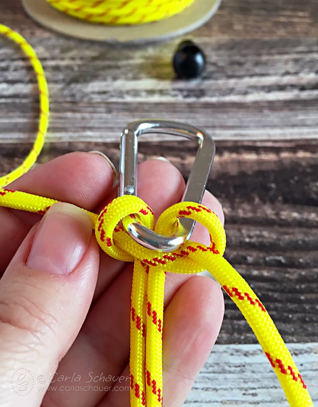 Tying paracord to Carabiner Clip. Part of tutorial to make paracord water bottle holders. | carlaschauer.com