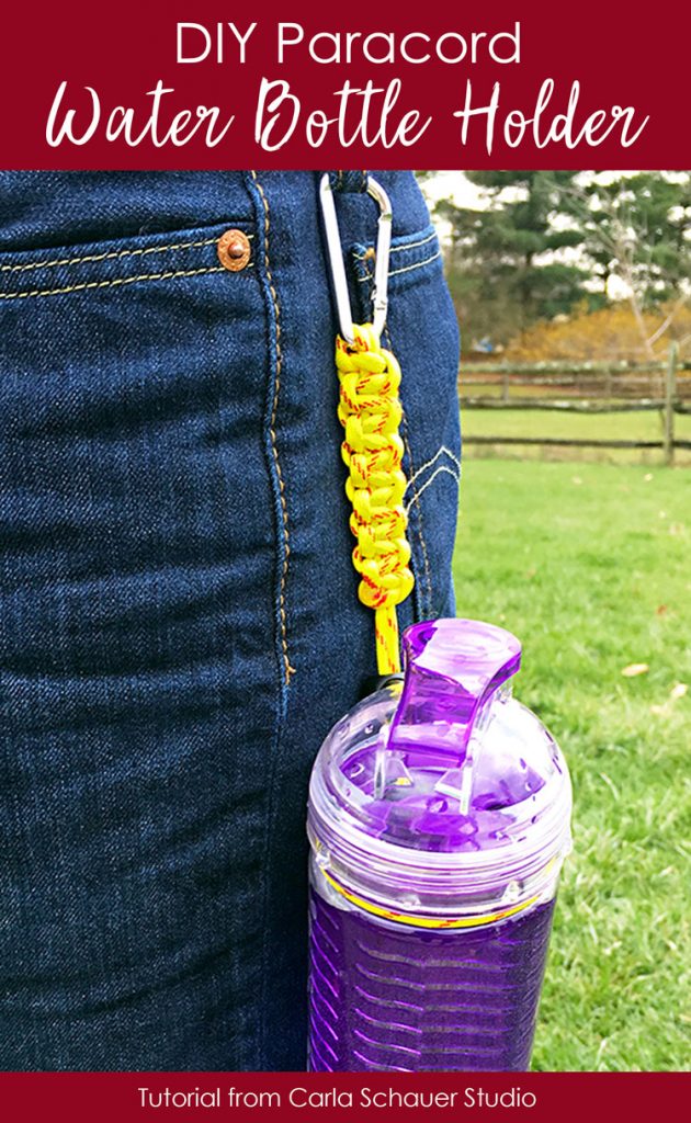 Yellow paracord bottle holder attached to belt loop and purple reusable bottle.