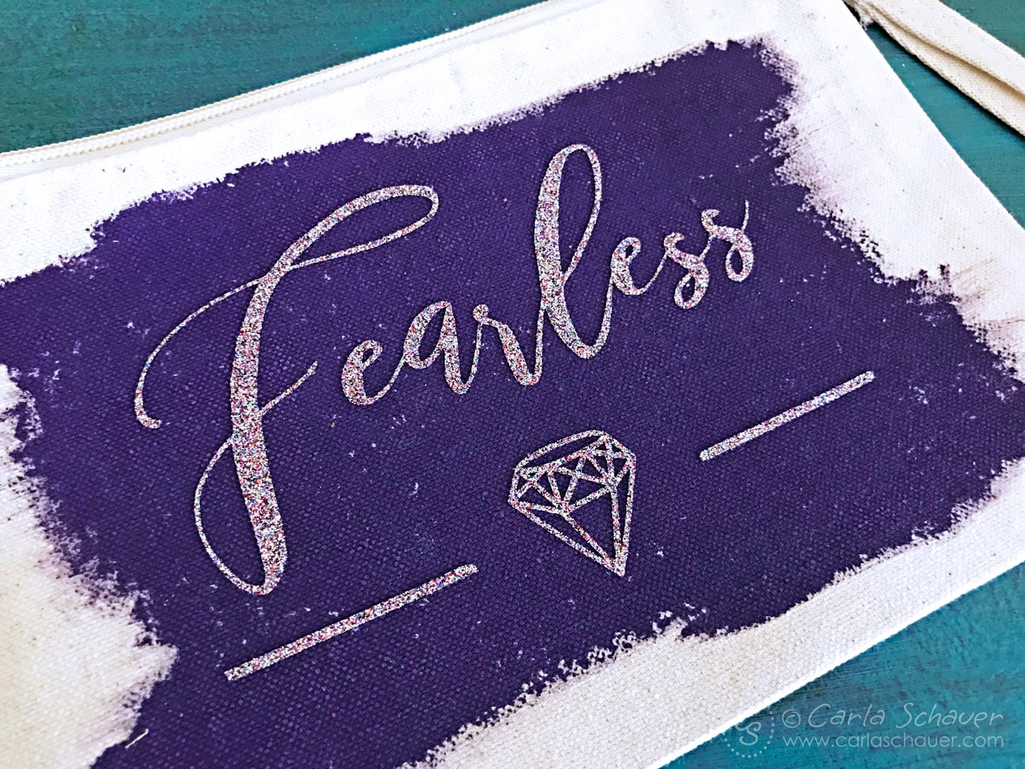 diamond and "fearless" text made from holographic glitter vinyl, on purple painted canvas zipper pouch.