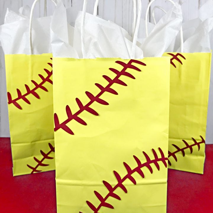 3 softball gift bags on red table.