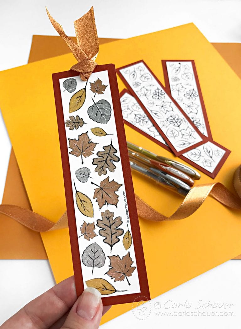 metallic colored leaf bookmark, gel pens, and uncolored leaf bookmarks on yellow background