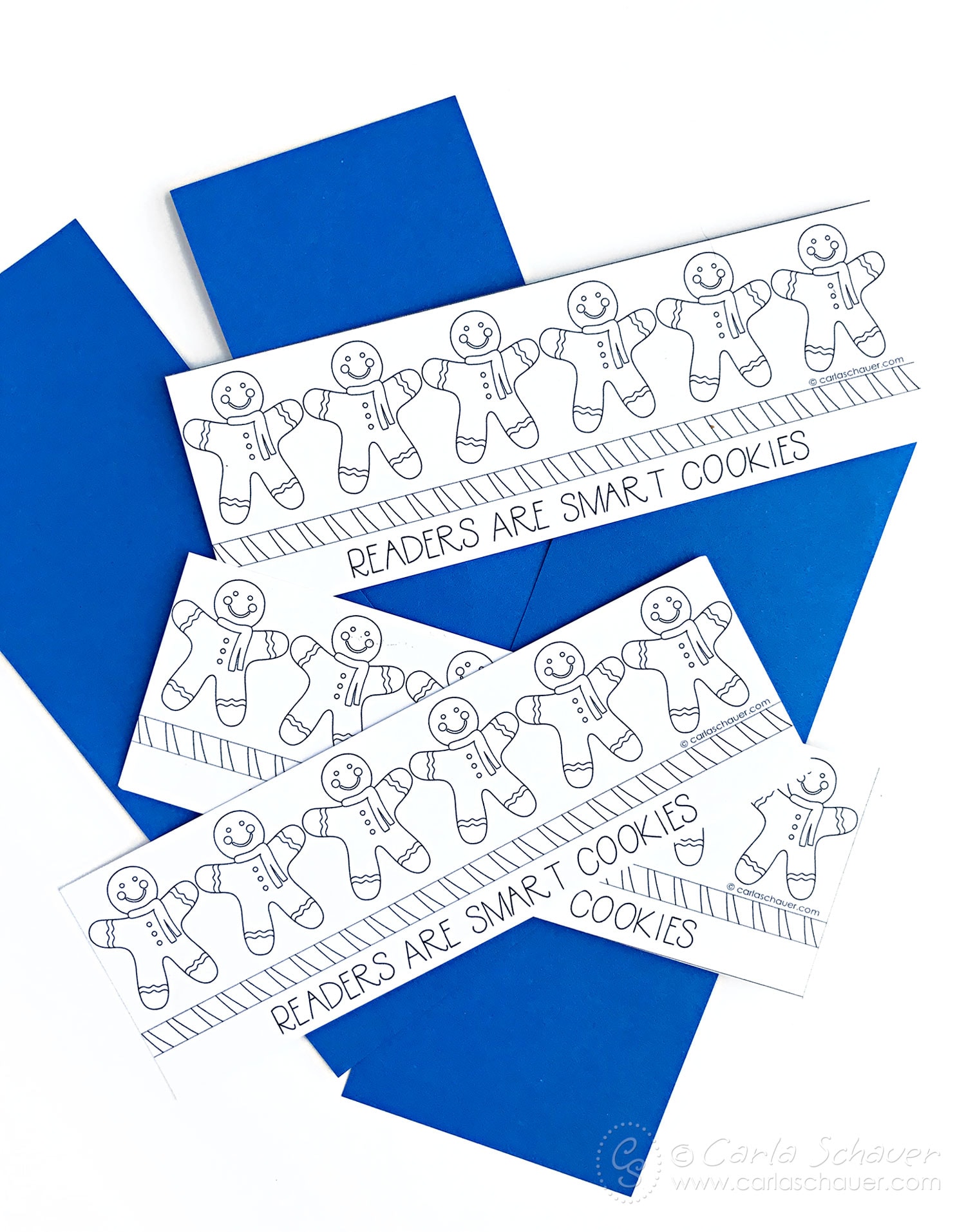 Printed gingerbread winter bookmarks on blue paper strips.