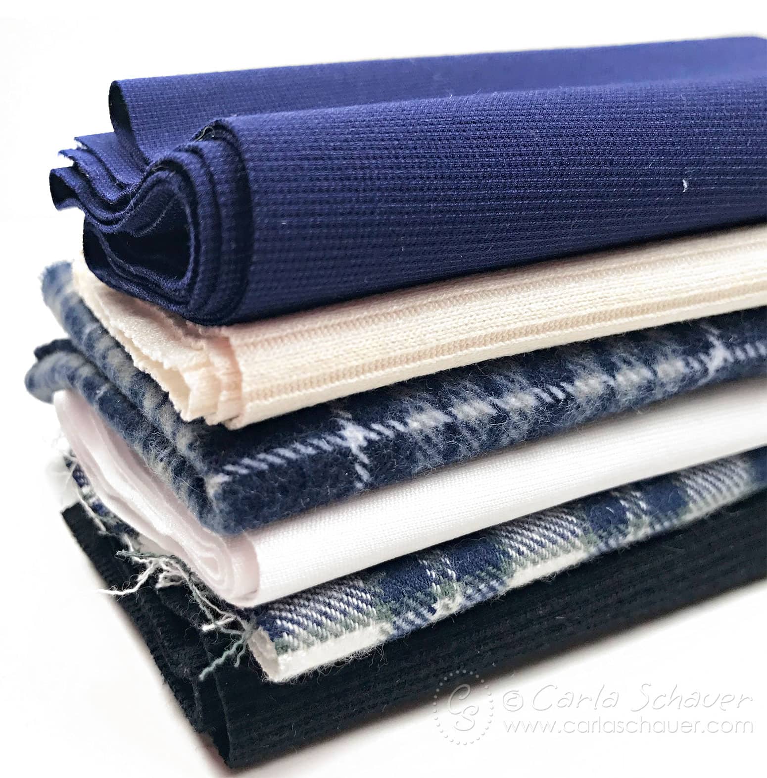 Stack of blue fabrics on white background.