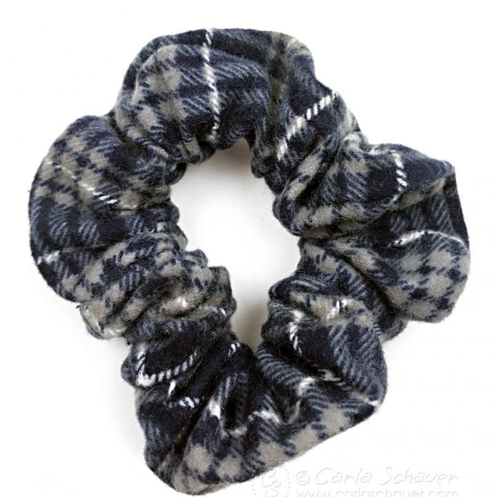 Plaid flannel hair scrunchie on white background.