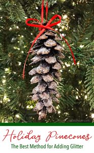Glittered pinecone hanging in christmas tree.