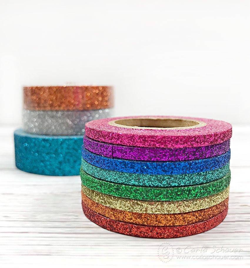 Stack of narrow Glittery Tape in rainbow colors, sitting on white background