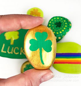 Gold and green shamrock painted rocks.