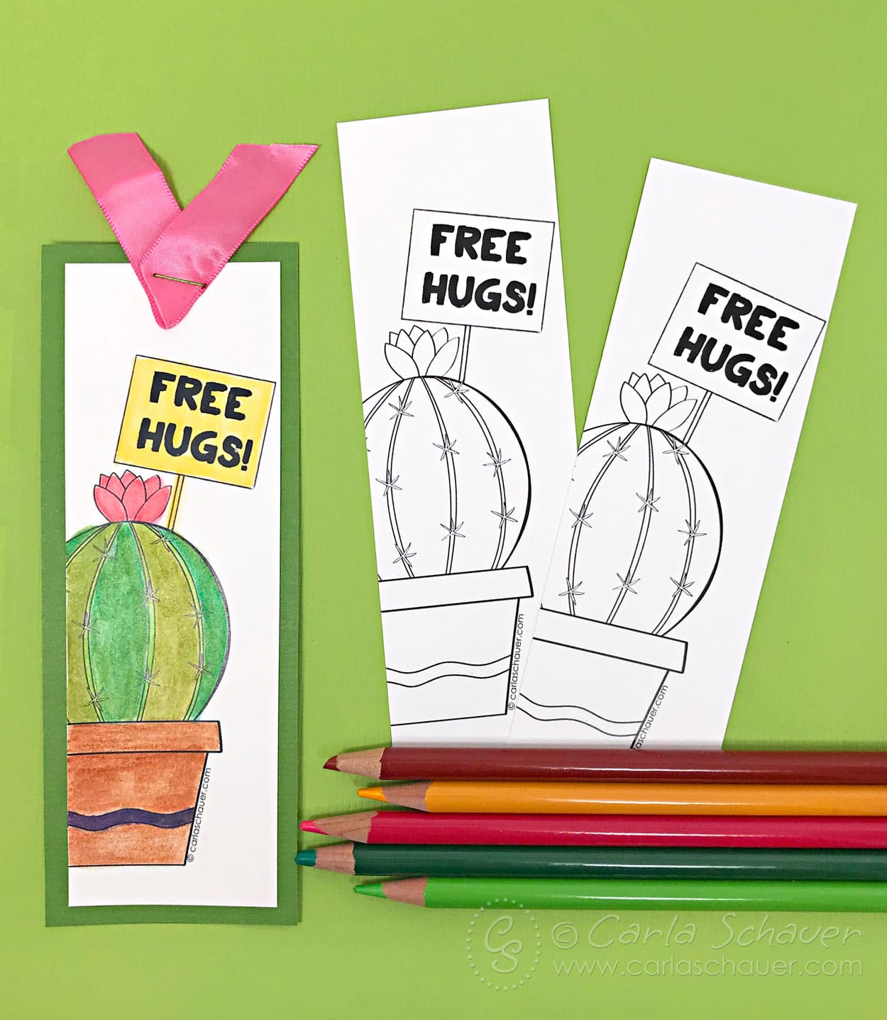 Hand-colored finished and plain diy cactus bookmarks with colored pencils on green background.
