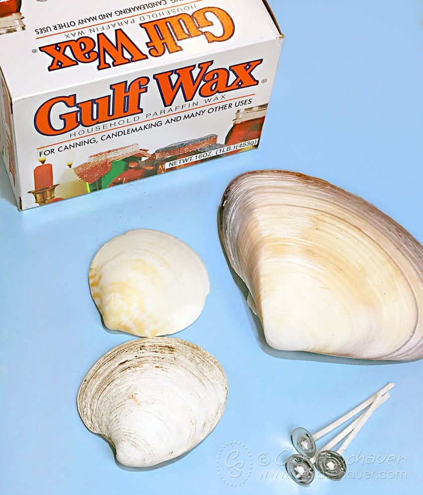 Supplies to make seashell candles on blue background