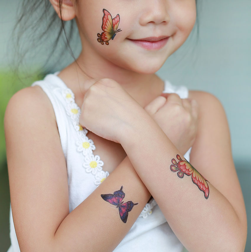 Child wearing 3 temporary tattoos.