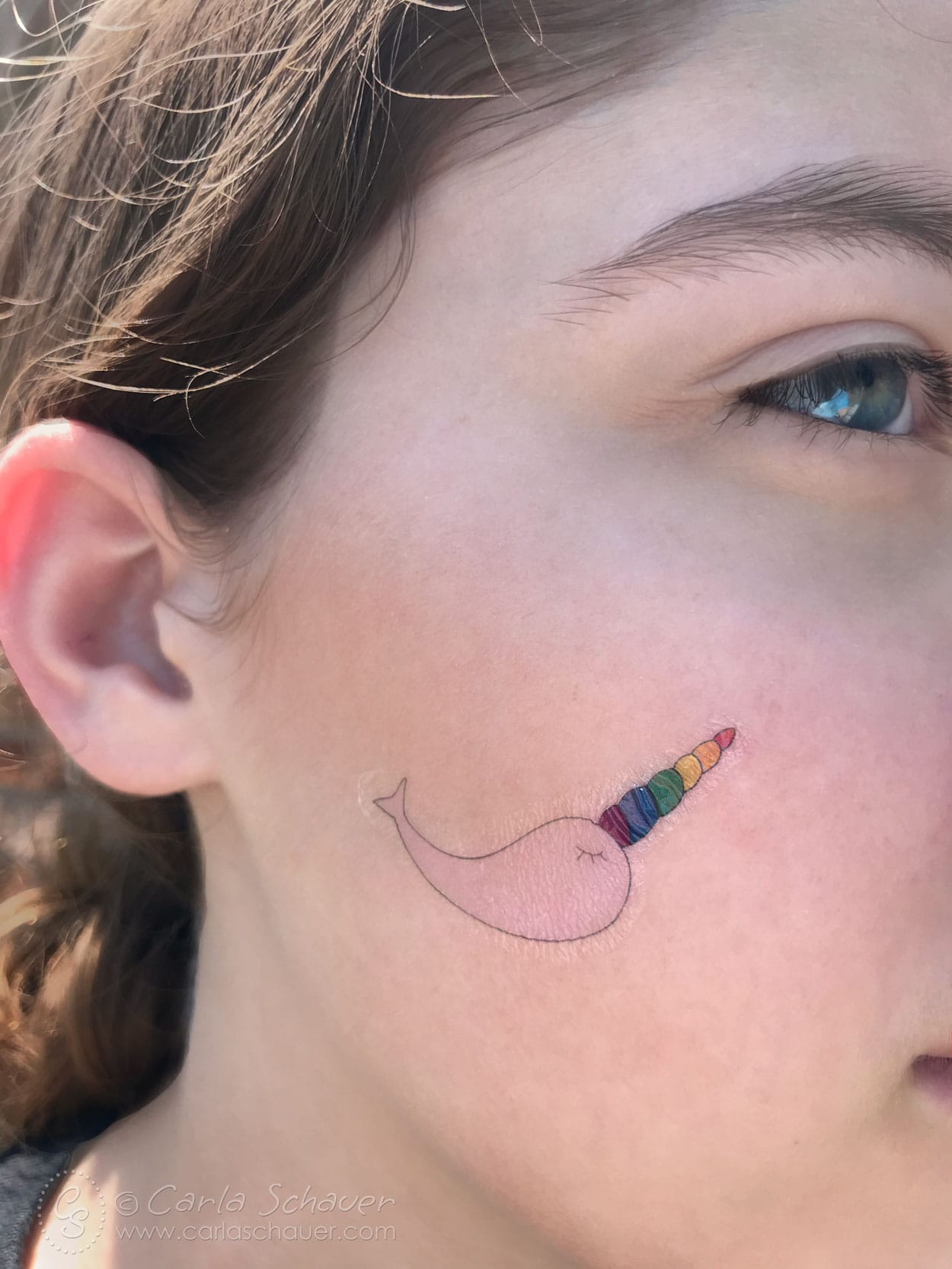 Narwhal Pride Temporary Tattoo on person's cheek.