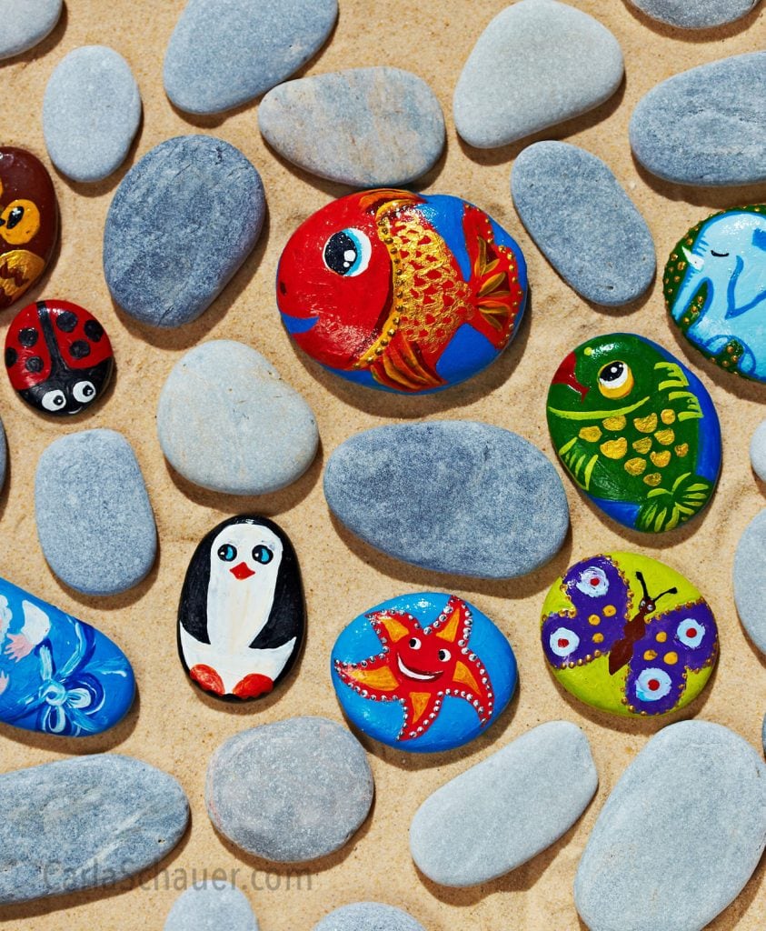A mix of animal-painted and unpainted flat stones.