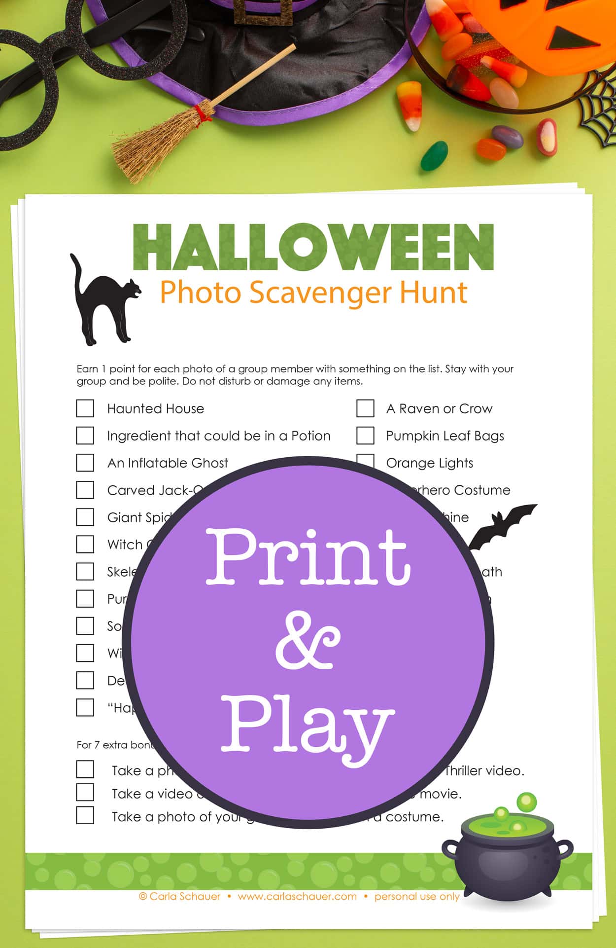 A green and black Halloween Scavenger Hunt list sits on a bright green background. At the top of the image are a variety of Halloween props, including a witch's hat, round eyeglasses, and an orange plastic pumpkin bucket with Halloween candy.