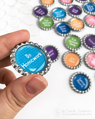 fingers holding bottle cap magnet with additional magnets in background