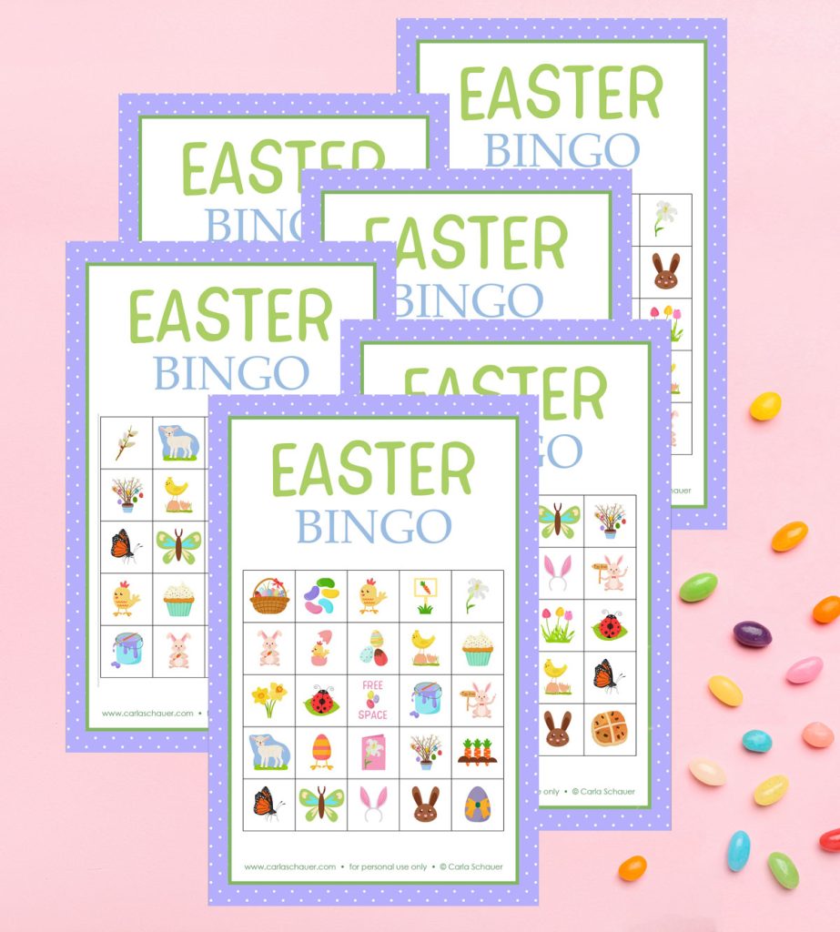 6 Easter bingo cards, each with a purple border and a 5x5 grid of spring icons. The cards are lying overlapped on a pink background, next to colorful jellybeans.